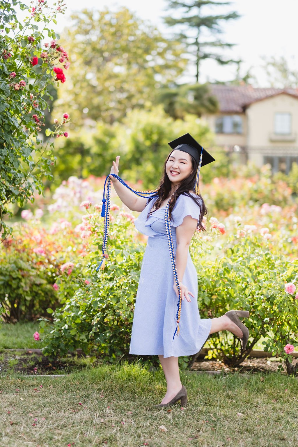 Graduate Holding Honor Society Ropes and Smiling