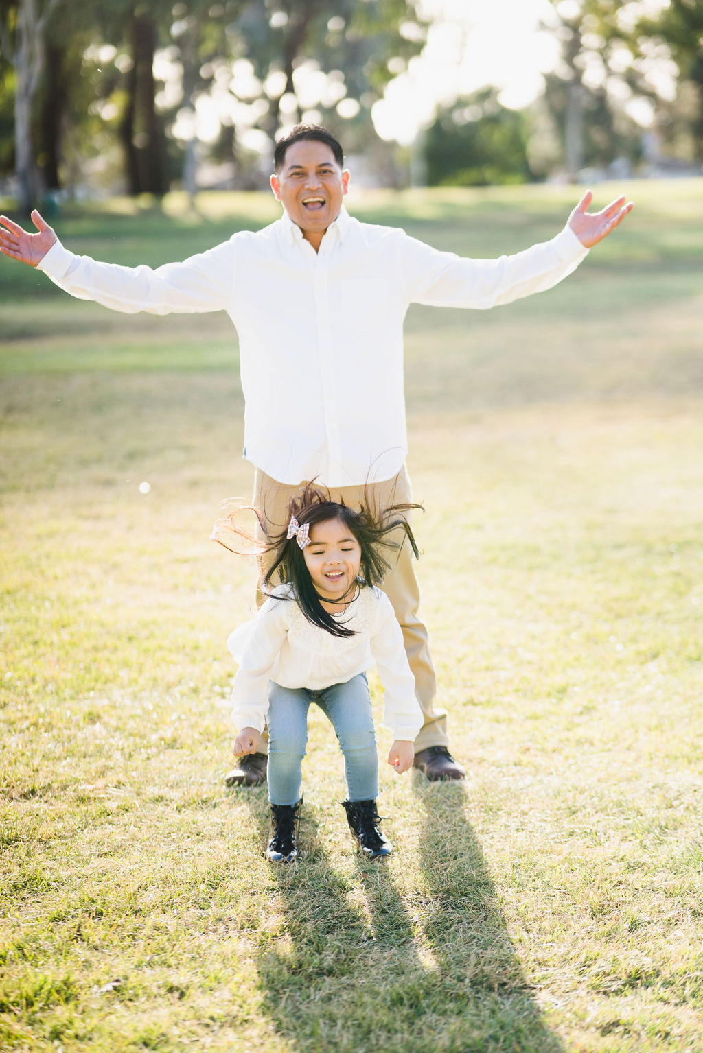 little girl jumping around her father