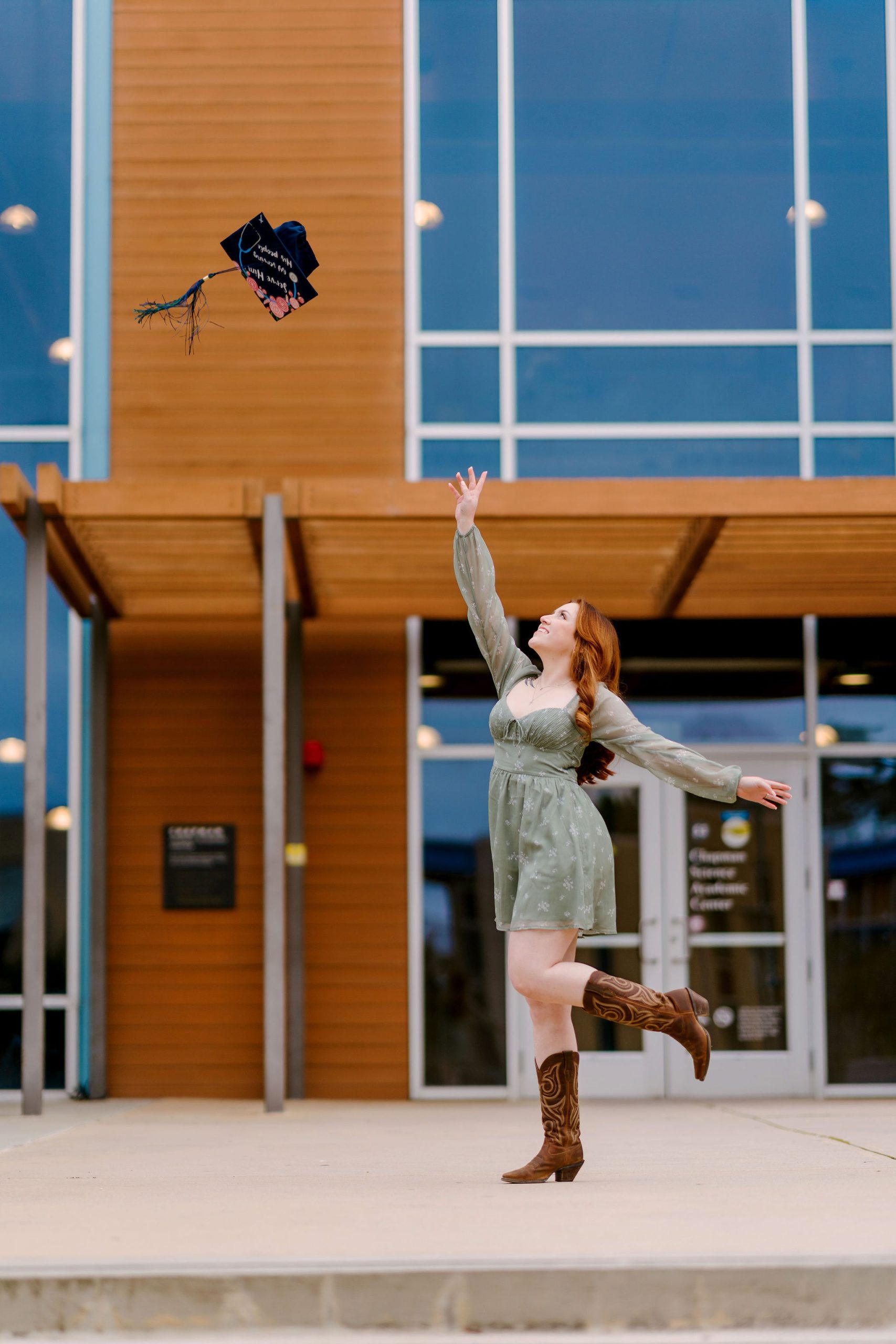 csumb graduate throwing graduation cap into the air